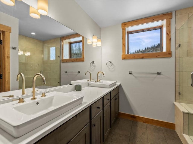 full bath featuring a shower stall, baseboards, and a sink