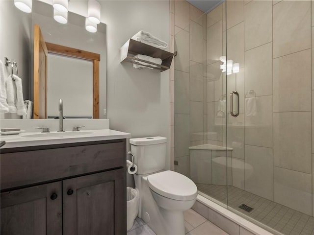 full bathroom with toilet, a stall shower, vanity, and tile patterned flooring