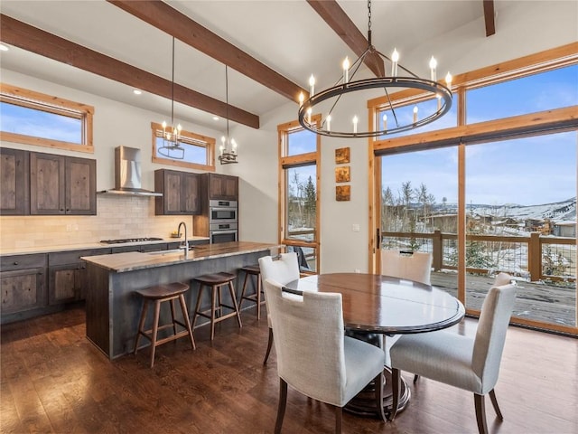 dining room with beamed ceiling, dark wood-type flooring, and a notable chandelier