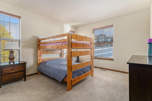 carpeted bedroom featuring multiple windows