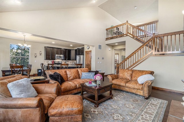 living room featuring dark hardwood / wood-style flooring, a notable chandelier, and high vaulted ceiling