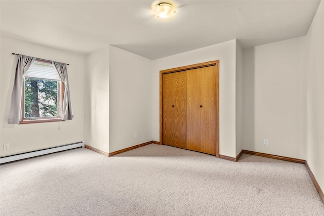 unfurnished bedroom with a baseboard heating unit, light carpet, and a closet