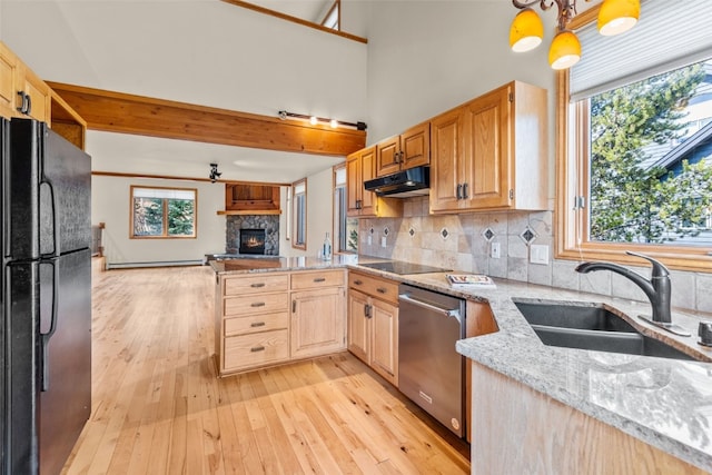 kitchen with light stone countertops, sink, pendant lighting, decorative backsplash, and black appliances