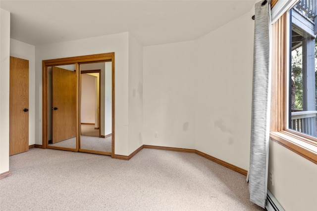 carpeted empty room featuring a baseboard radiator