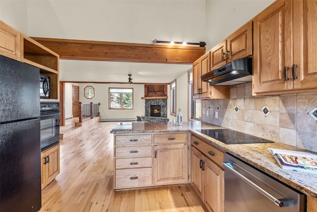 kitchen featuring kitchen peninsula, light stone countertops, tasteful backsplash, black appliances, and light hardwood / wood-style floors