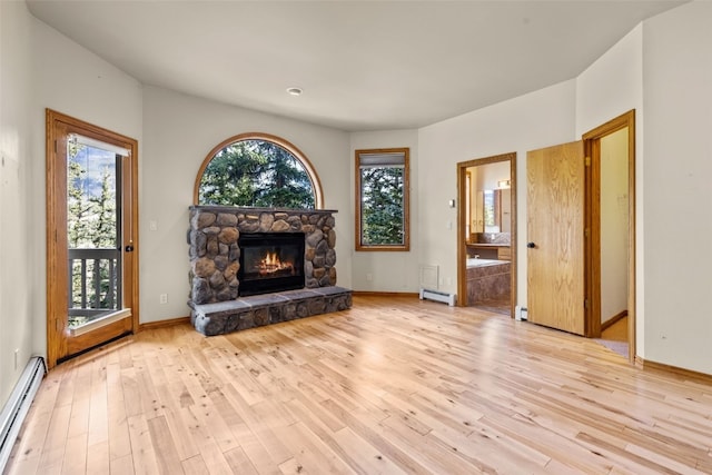 unfurnished living room with a fireplace, a baseboard radiator, and light hardwood / wood-style flooring