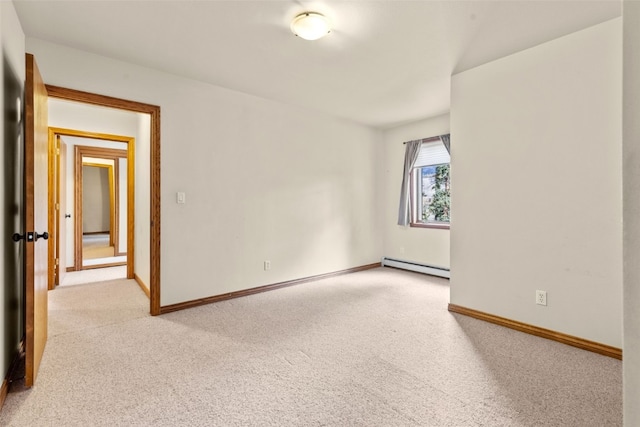 spare room with light carpet and a baseboard heating unit