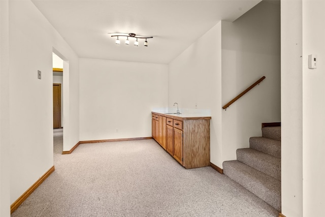 bar featuring light carpet and sink