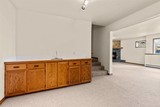 bar with sink, light colored carpet, and a fireplace