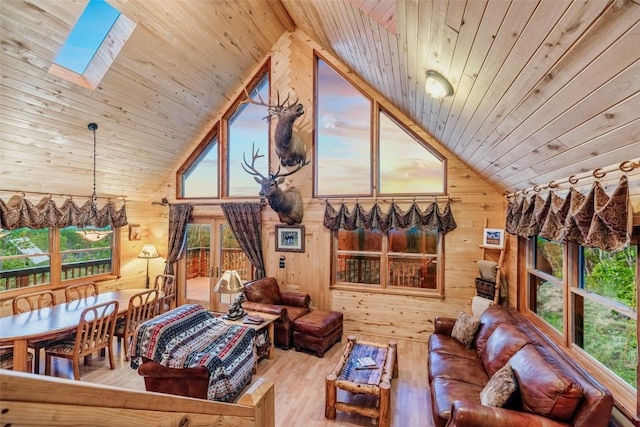 interior space with hardwood / wood-style floors, wooden ceiling, high vaulted ceiling, wooden walls, and a skylight