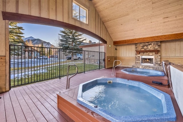 wooden terrace with a mountain view and an outdoor stone fireplace