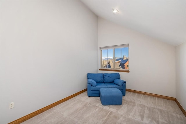 living area featuring light colored carpet and vaulted ceiling