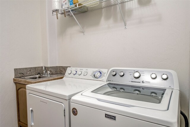 clothes washing area featuring sink and washing machine and clothes dryer