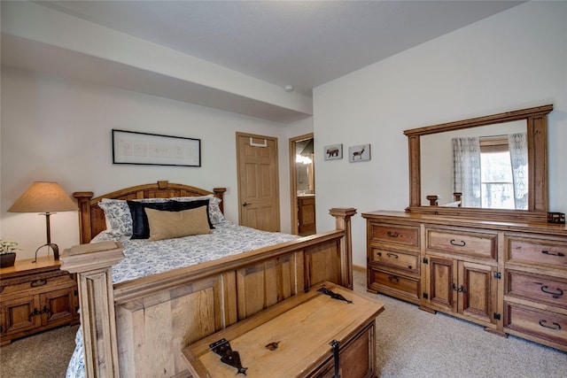 bedroom featuring light colored carpet and ensuite bath