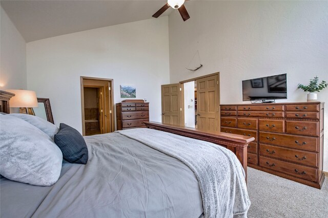 bedroom with carpet, connected bathroom, high vaulted ceiling, and ceiling fan