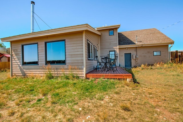 rear view of property with a deck and a yard