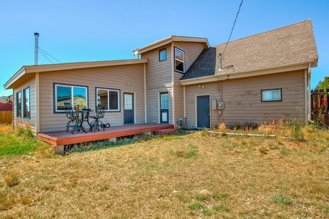 back of property with a lawn and a wooden deck