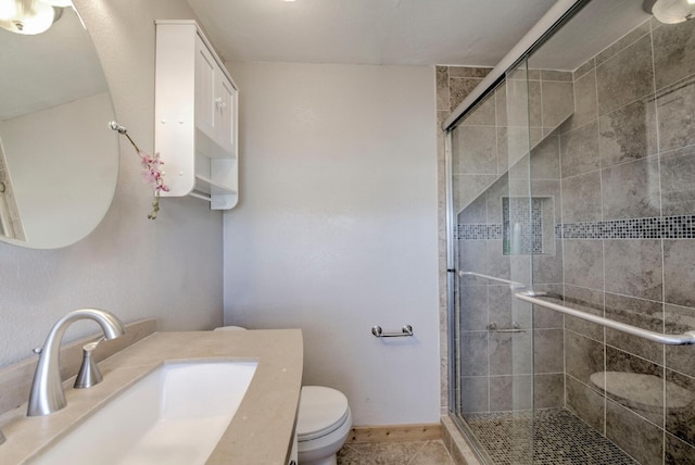 bathroom with tile patterned flooring, vanity, an enclosed shower, and toilet