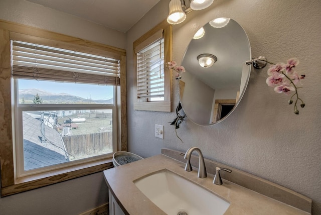 bathroom with a mountain view, vanity, and a healthy amount of sunlight