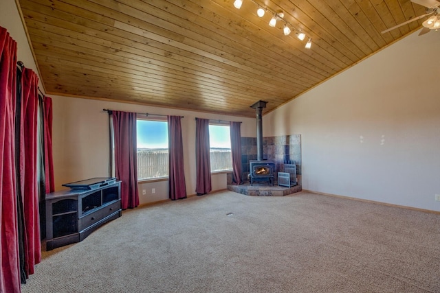 unfurnished living room with vaulted ceiling, carpet floors, a wood stove, and wood ceiling