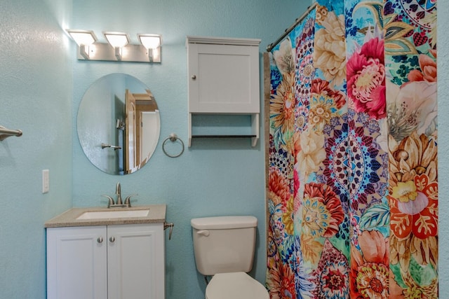 bathroom with vanity, toilet, and walk in shower