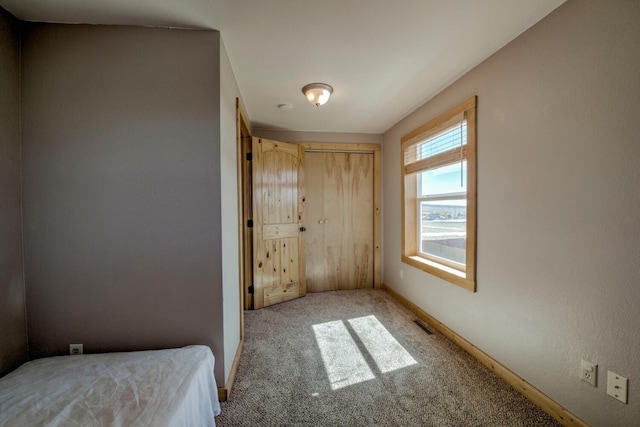 unfurnished bedroom featuring a closet and light colored carpet