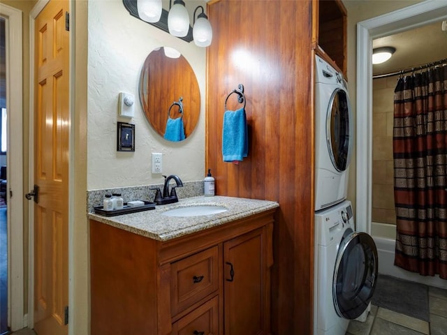 bathroom featuring shower / bath combo with shower curtain, vanity, tile patterned floors, and stacked washer / drying machine