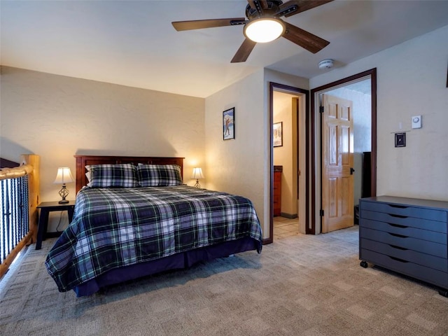 bedroom featuring ensuite bath, light carpet, and ceiling fan