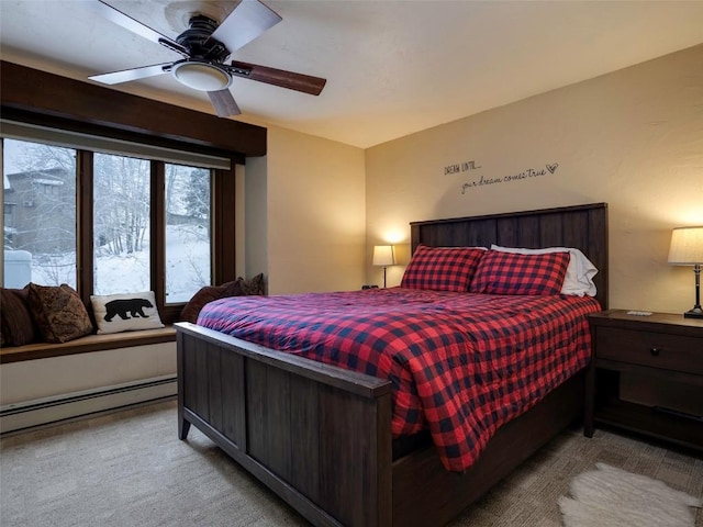 carpeted bedroom featuring a baseboard radiator and ceiling fan