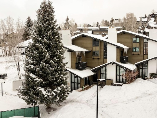 view of snow covered back of property