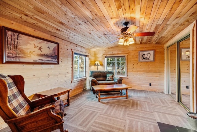 living area featuring ceiling fan, wooden ceiling, and wood walls