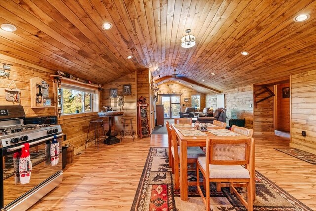 dining space with wooden walls, plenty of natural light, wood ceiling, and vaulted ceiling