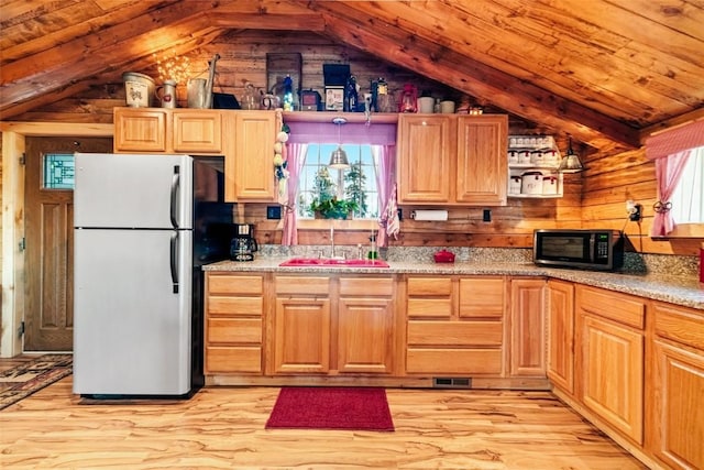 kitchen featuring decorative light fixtures, stainless steel refrigerator, a healthy amount of sunlight, and sink