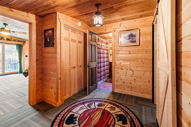 hall featuring wooden ceiling and wooden walls