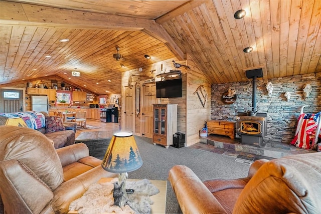 living room with lofted ceiling with beams, a wood stove, wooden walls, and wood ceiling