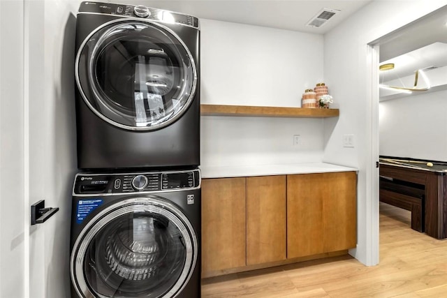 washroom featuring billiards, light hardwood / wood-style flooring, and stacked washer and dryer