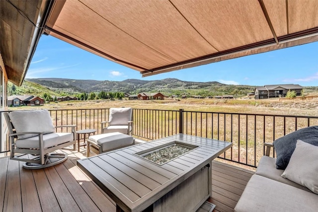 deck with an outdoor living space with a fire pit and a mountain view