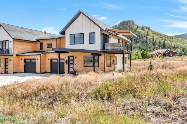 view of front of home featuring board and batten siding, a mountain view, driveway, and a garage