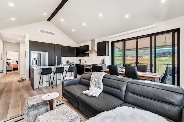 living room with high vaulted ceiling, light wood-style flooring, beamed ceiling, and visible vents