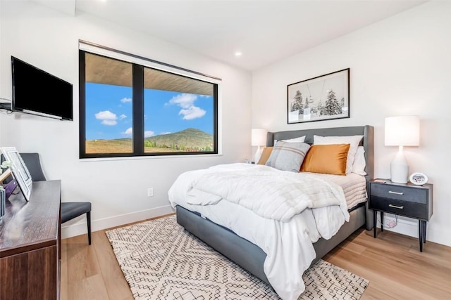 bedroom with light wood finished floors, baseboards, and recessed lighting