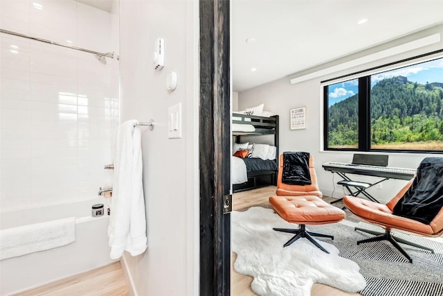 bathroom with shower / bath combination and wood finished floors