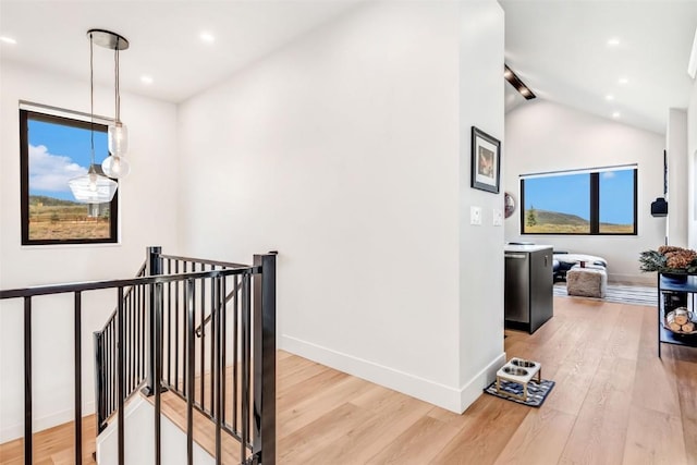 hall featuring baseboards, an upstairs landing, and wood finished floors