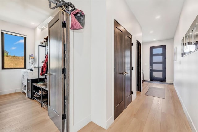 hallway with light wood-style floors, baseboards, and recessed lighting