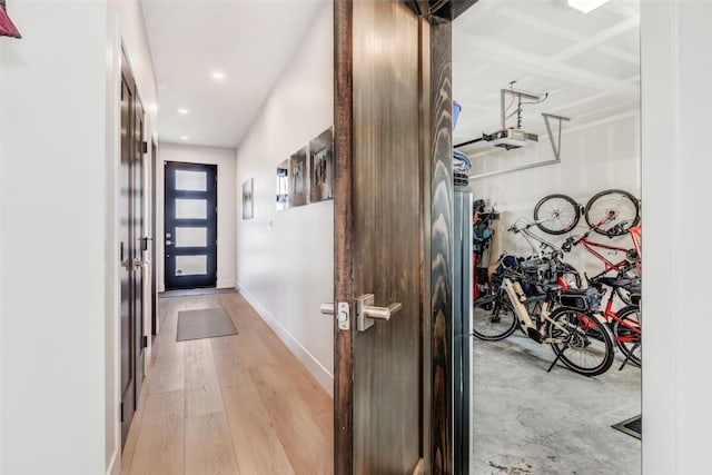 doorway featuring light wood-type flooring, recessed lighting, and baseboards