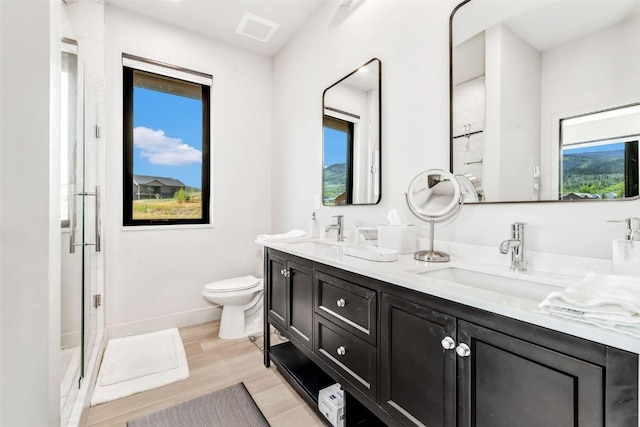 full bath with toilet, wood finished floors, a sink, and visible vents