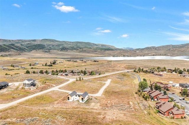 birds eye view of property with a water and mountain view