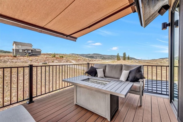 wooden deck with an outdoor living space with a fire pit and a mountain view