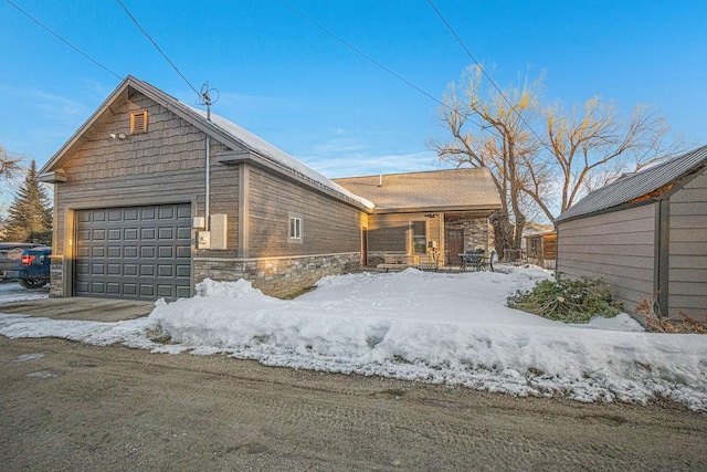 exterior space with a garage and stone siding