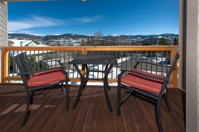 snow covered back of property with a mountain view