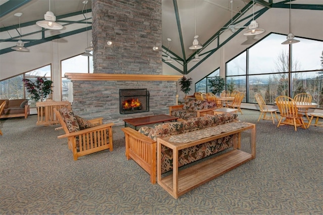 carpeted living room with beamed ceiling, a stone fireplace, and high vaulted ceiling